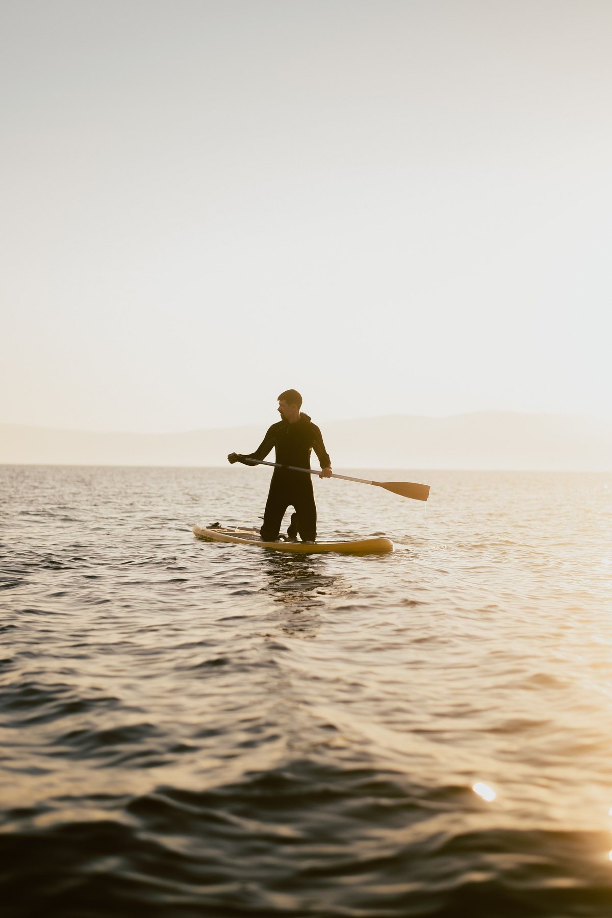 Paddleboard o zachodzie słońca nad wodą